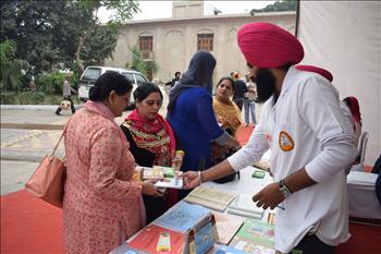Volunteers exhibiting books published in line with missions of Living with Gurbani and Nature care
