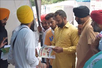 Volunteers exhibiting books published in line with Atam Pargas mission of living with Gurbani movement and nature care movement