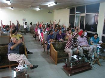Attendees showing their consent by raising their hands on the views of Dr. Varinderpal Singh.
